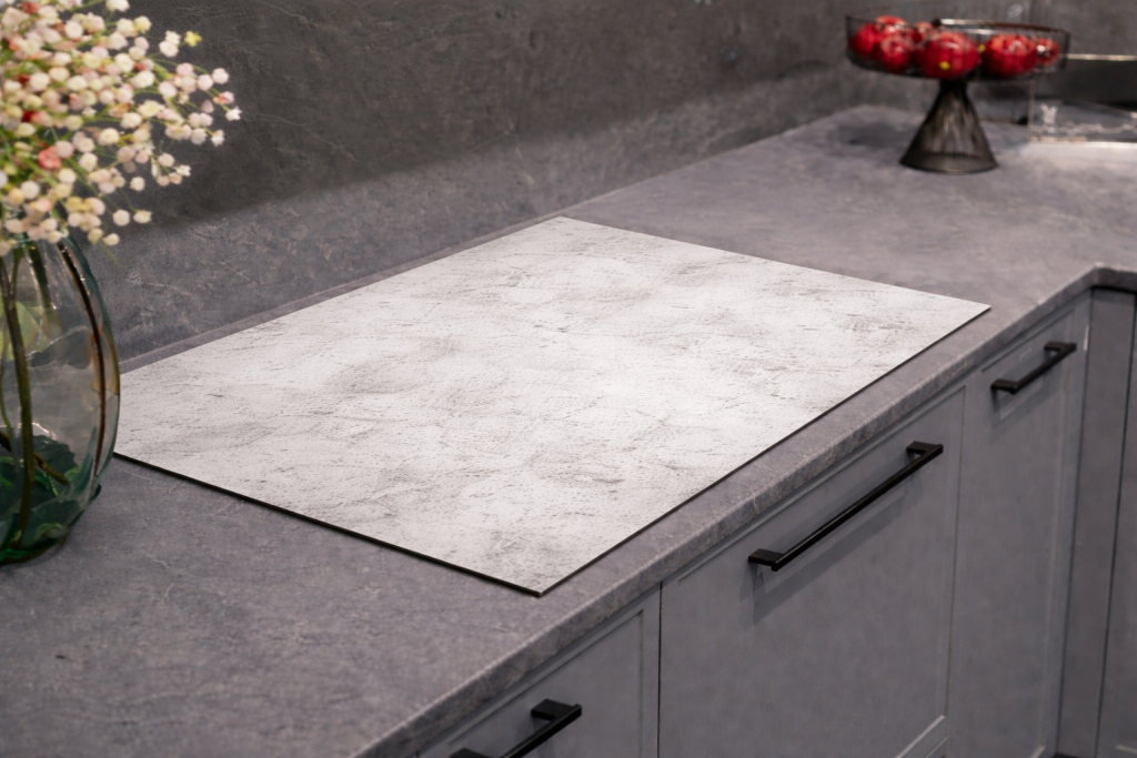 Inductiebeschermer met een korrelige grijze graniet- of steentextuur.