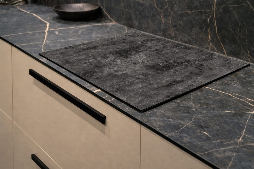 Inductiebeschermer met een minimalistische lichtgrijze betonlook.